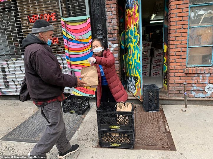 27054560-8209061-A_man_picks_up_a_bag_full_of_food_at_the_St_Joseph_House_Catholi-a-30_1586554703503